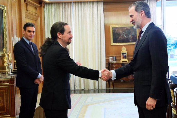 El Rey Felipe VI saluda al vicepresidente  Pablo Iglesias en el Palacio de la Zarzuela, con Pedro Sánchez en segundo plano