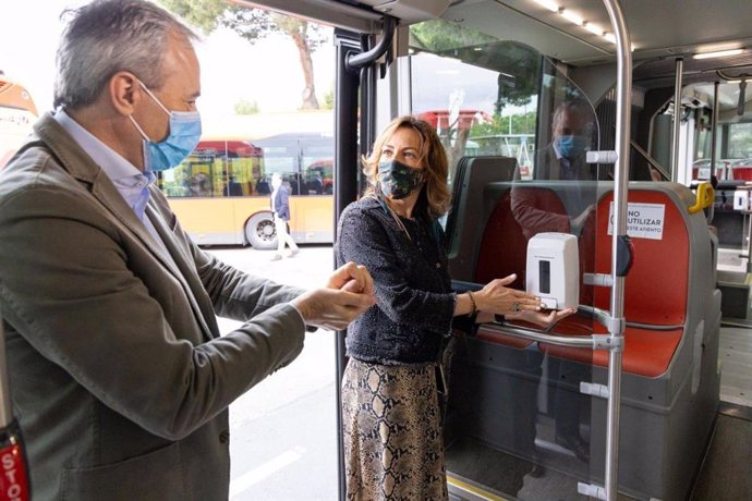 El alcalde de Zaragoza. Jorge Azcón, preuba un dispensador de gel en un autobús