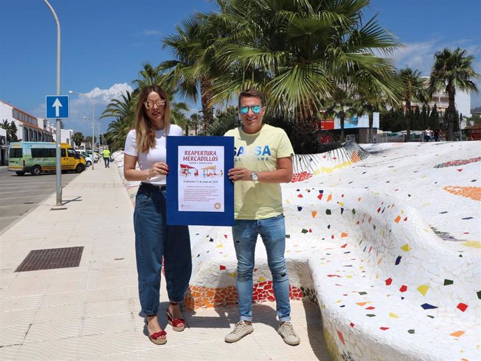 La concejala de Comercio de Torrox, Sandra Extremera, y el alcalde, Oscar Medina, con el cartel de reapertura de mercadillos el 15 de junio