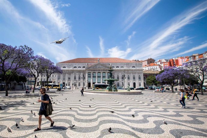 Un home passeja per una plaa de Lisboa