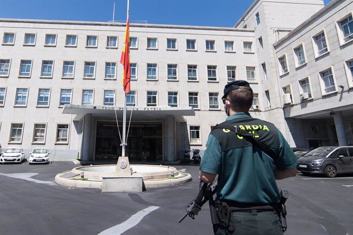 Un agente de la Guardia Civil guarda un minuto de silencio con la bandera de España a media asta en el Cuartel General del Estado Mayor de la Defensa