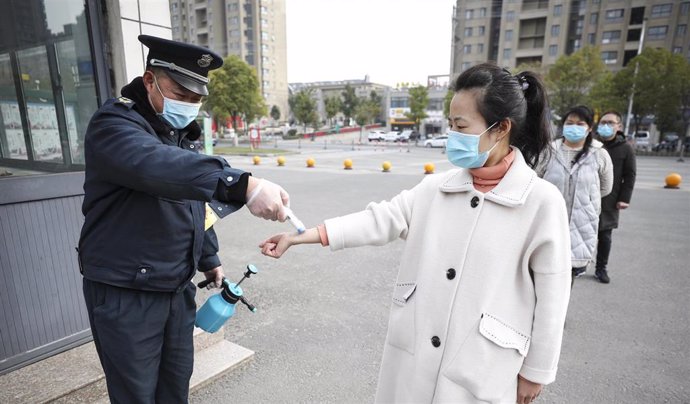 Personal sanitario toma la temperatura a una profesora de una escuela de educación primaria del municipio de Tianjin, en el norte de China.