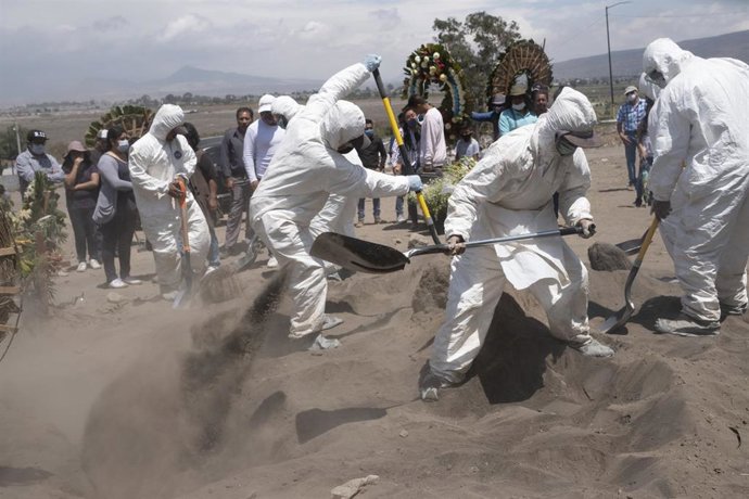 Trabajadores de un cementerio en la ciudad de Chalco, en Estado de México, cavan fosas para hacer hueco a los nuevos fallecidos por la COVID-19.