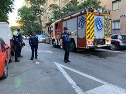 Imagen de efectivos de Policía Municipal de Madrid junto a un vehículo de bomberos del Ayuntamiento de la capital en las inmediaciones de la vivienda donde ha muerto un hombre de 58 años tras un incendio en su vivienda.