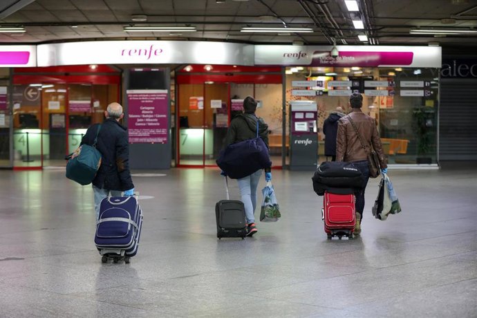 Viajeros con maleta en el hall de la estación de tren Madrid  Puerta de Atocha 