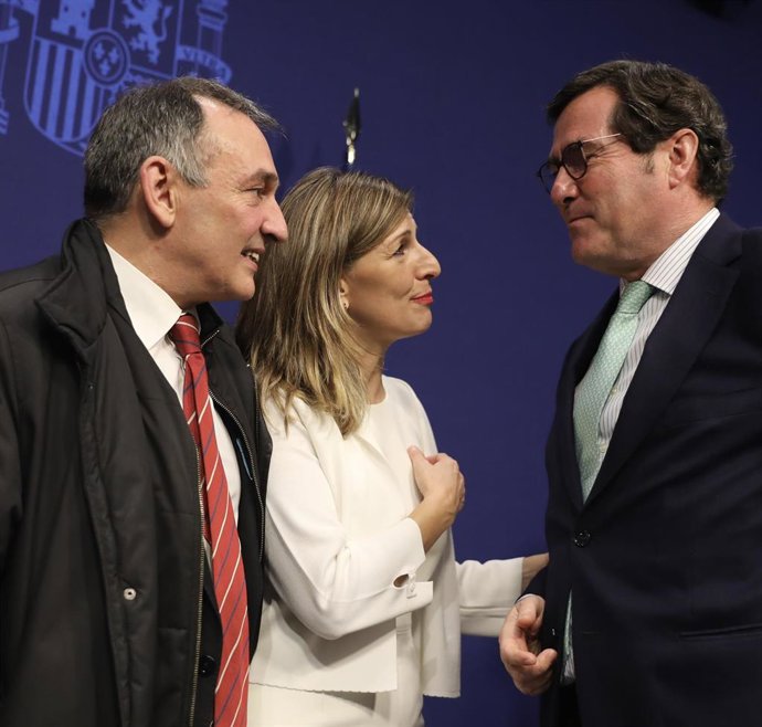 La ministra de Trabajo, Yolanda Díaz, habla con el presidente de la CEOE, Antonio Garamendi, en presencia del diputado de Unidas Podemos Enrique Santiago