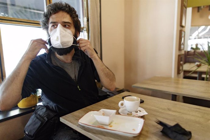 Luca, un cliente en el restaurante Quercus, se coloca la mascarilla tras desayunar. En Madrid (España), a 8 de junio de 2020.