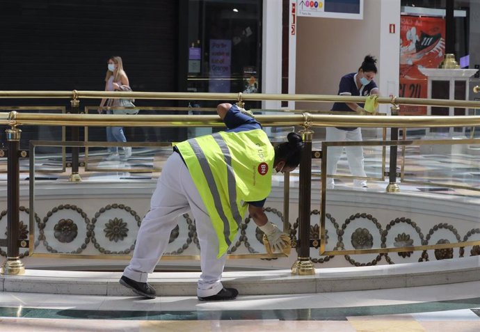 Dos trabajadoras de la limpieza limpian las barandillas del Centro Plaza Norte 2
