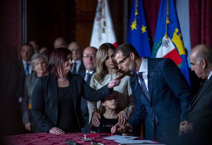 El primer ministro de Malta, Robert Abela, besa un crucifijo cuando asumió el cargo.