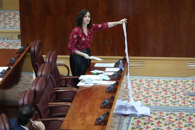La presidenta de la Comunidad de Madrid, Isabel Díaz Ayuso, muestra una lista de residencias de mayores atendidas en la crisis del coronavirus durante un sesión plenaria en la Asamblea de Madrid