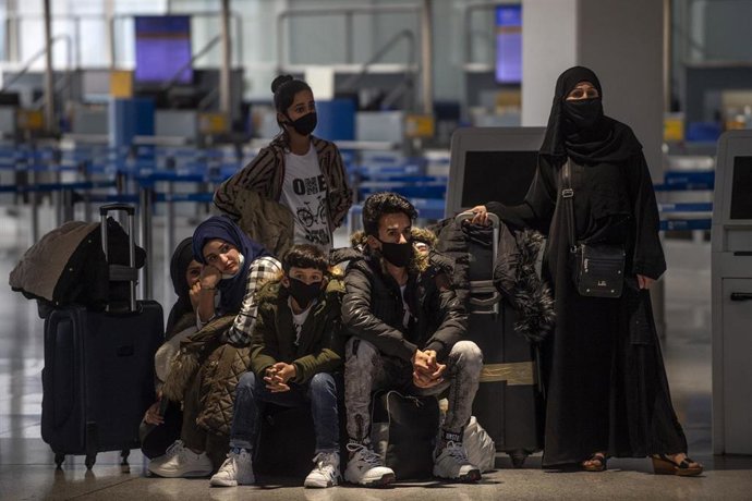 Migrantes y refugiado esperan para embarcar en Atenas rumbo a Londres