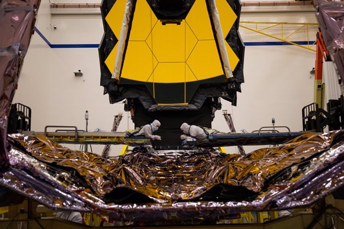 Los técnicos inspeccionan una parte crítica del telescopio espacial James Webb conocida como el conjunto de torre desplegable después de extenderlo completamente en la misma maniobra que realizará una vez en el espacio