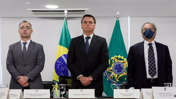 El ministro de Justicia, André de Almeida Mendona ; el presidente de Brasil, Jair Bolsonaro; y el titular de Economía, Paulo Guedes; durante un minuto de silencio en honor de las víctimas de la COVID-19.
