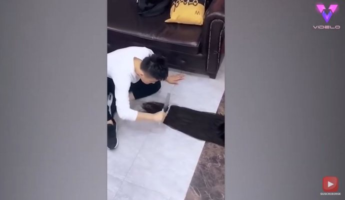 Un peluquero utiliza un cuchillo carnicero para cortar el pelo a sus clientes en Shanghái