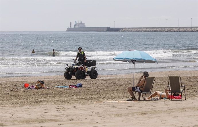 Un agente de la Policía Local de Valencia vigila desde un quad la Playa de la Malvarrosa, con bandera verde durante el primer día de la Fase 2, cuando se puede acceder a las playas de la misma provincia, isla o unidad territorial de referencia 