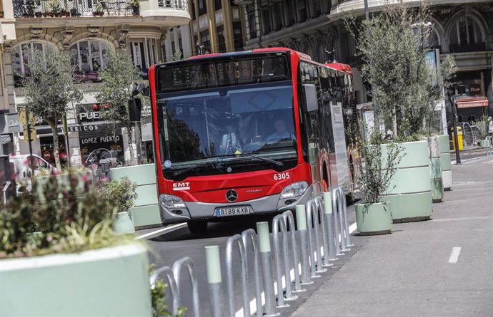 Un autobús de la línea C1 pasa al lado de los maceteros colocados en la Plaza del Ayuntamiento de Valencia, 