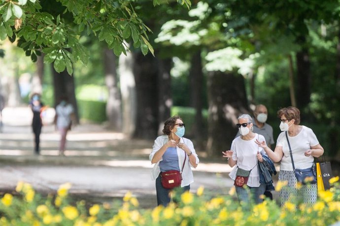 Varias mujeres pasean protegidas con mascarillas en el Parque de El Retiro 