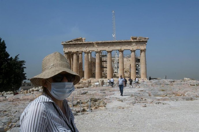 Una mujer con mascarilla frente al Partenón de Atenas