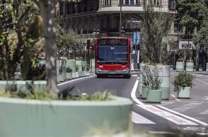 Un autobús de la línea C1 pasa al lado de los maceteros colocados en la Plaza del Ayuntamiento de Valencia