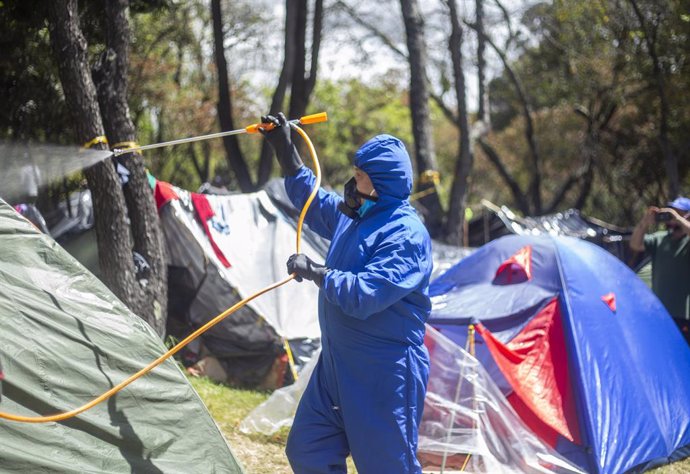Un hombre desinfecta un campamento en el norte de Colombia