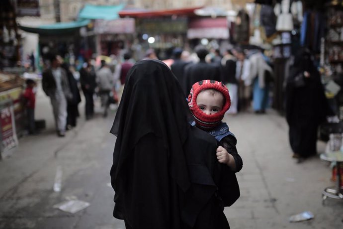Una madre pasea con su hijo en Saná