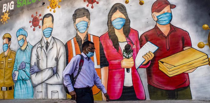 Mural de personas con mascarillas en Nueva Delhi