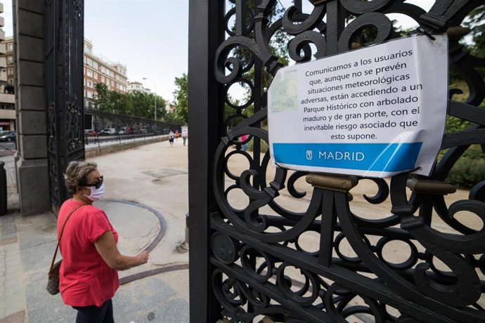Una mujer entra al Parque de El Retiro después de su reapertura tras haber sido cerrado por el Ayuntamiento de Madrid