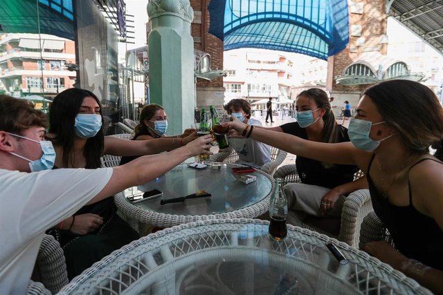 Varias personas disfrutan de uno de los bares del Mercado de Colón durante la fase 2 de la desescalada en la pandemia de coronavirus COVID19