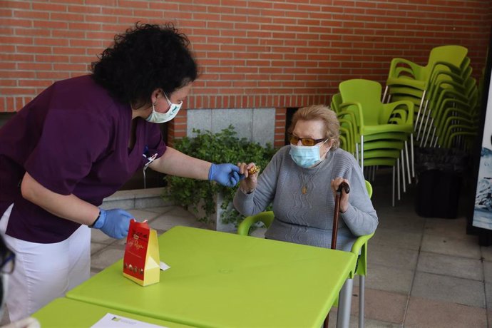 Una gerocultora ayuda a levantarse a un residente del Centro Casaverde Navalcarnero (Madrid) en su primer día de visitas desde que se cerró por el coronavirus