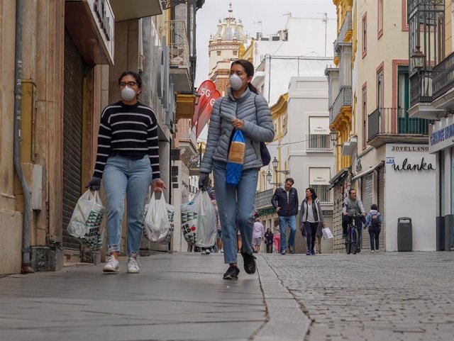 Dos personas con mascarillas por la calle Tetuán  de Sevilla a 14 de marzo del 2020