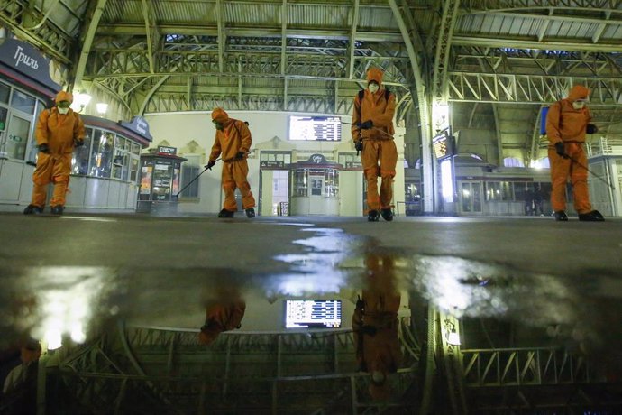 Trabajadores del Ministerio de Emergencias desinfectando una estación de trenes en San Petersburgo