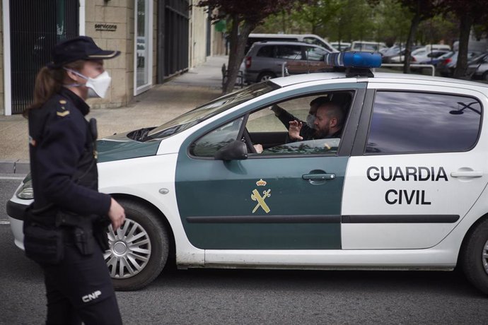 Un vehículo de la Guardia Civil pasa junto a un control de la Policía Nacional en Pamplona
