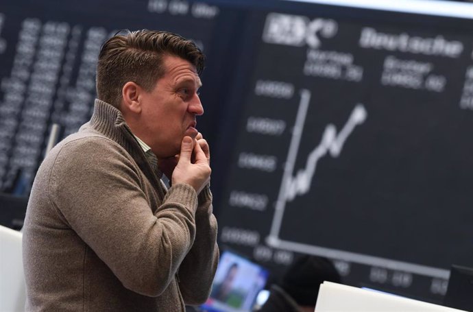 28 December 2018, Hessen, Frankfurt/Main: A stock trader makes a telephone call at the trading floor of the Frankfurt Stock Exchange on the last trading day of the year. Photo: Arne Dedert/dpa