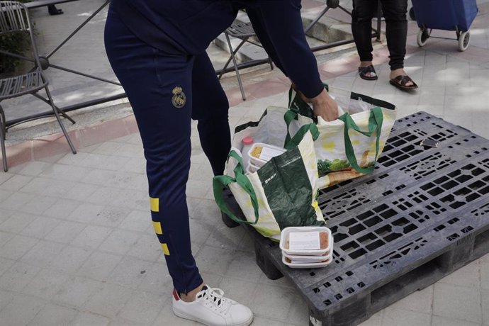 Voluntarios de la Fundación Madrina, reparten alimentos a las madres que esperan en las inmediaciones de la Parroquia Santa María Micaela y San Enrique. En Madrid, (España), a 12 de junio de 2020.