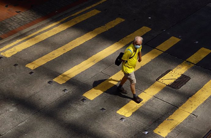 Un hombre cruza un paso de peatones en China.