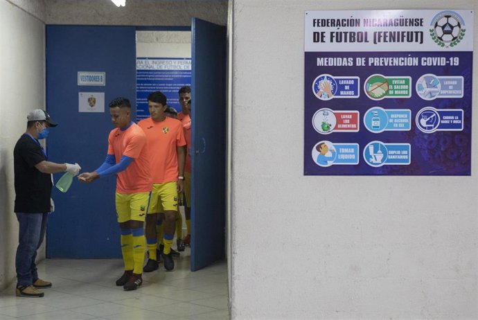 Jugadores se lavan las manos antes de un partido de fútbol en Managua