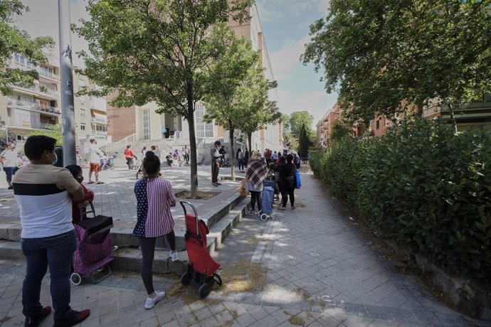 Decenas de mujeres esperan en las inmediaciones de la Parroquia Santa María Micaela y San Enrique donde la Fundación Madrina reparte diariamente unas 200 bolsas a madres y sus bebés. En Madrid, (España), a 12 de junio de 2020.