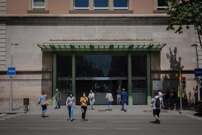 Diverses persones caminen prop de la porta de l'Hospital Clínic de Barcelona, Catalunya, (Espanya), a 27 de maig de 2020.