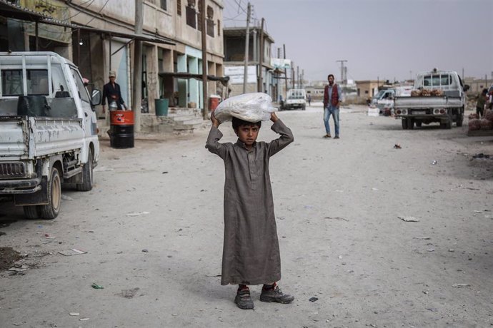 Un niño con un saco de comida en Siria