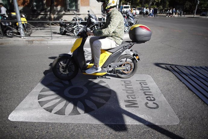 Una moto pasa por encima de una señal de Madrid Central que indica restricciones al tráfico en el centro de la capital 