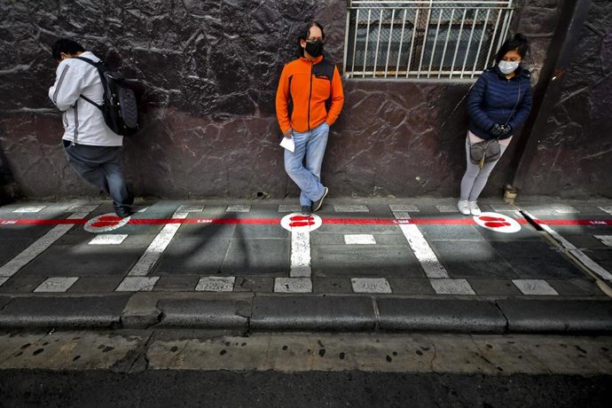 Personas haciendo una cola con distancia en La Paz