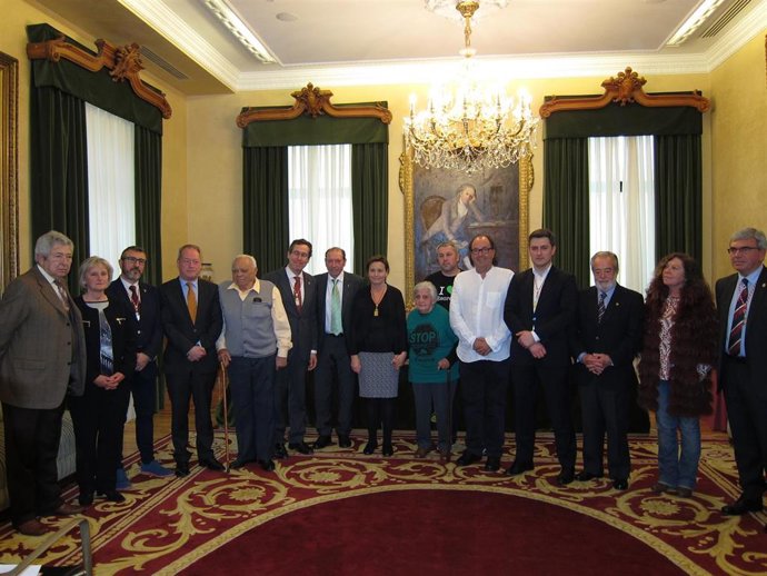     Manolo Llanos, tras recibir la Medalla de la Plata de la Villa de Gijón en 2016, junto a otros galardonados y miembros de la Corporación gijonesa