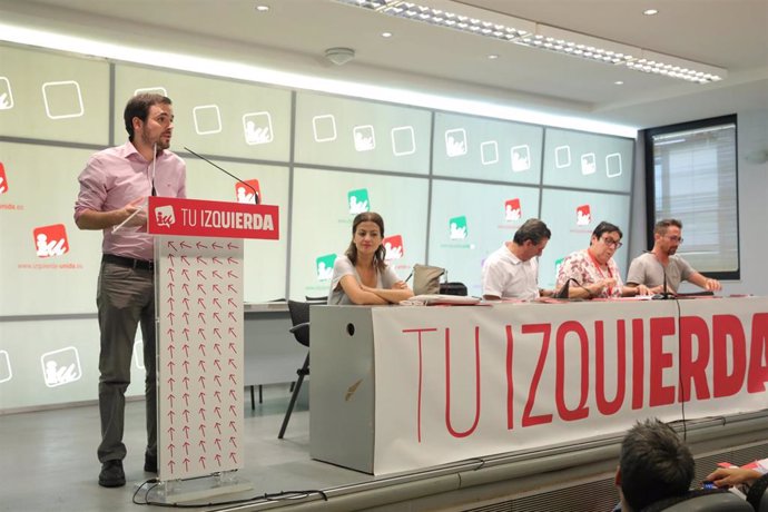 El coordinador federal de IU, Alberto Garzón, en l a sede de IU. Al fondo, el responsable de Organización, Ismael González (1d).