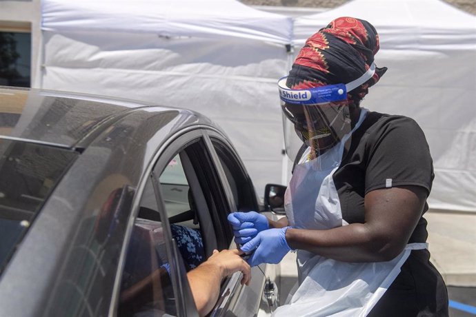 03 June 2020, US, Los Angeles: A medical worker wears protective equipment takes a sample from a person at a drive-through COVID-19 testing clinic at the Weingart YMCA Wellness and Aquatic Center. Photo: Hans Gutknecht/Orange County Register via ZUMA/dpa