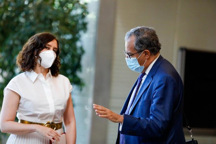 La presidenta de la Comunidad de Madrid, Isabel Díaz Ayuso (i) y el consejero de Educación, Enrique Ossorio (d) conversan antes de la sesión plenaria en la que se debaten los planes de la Comunidad de Madrid ante el fin del estado de alarma, en Madrid.