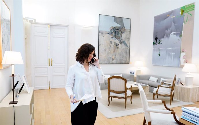 La presidenta de la Comunidad de Madrid, Isabel Díaz Ayuso, habla por teléfono en su despacho de la Real Casa de Correos
