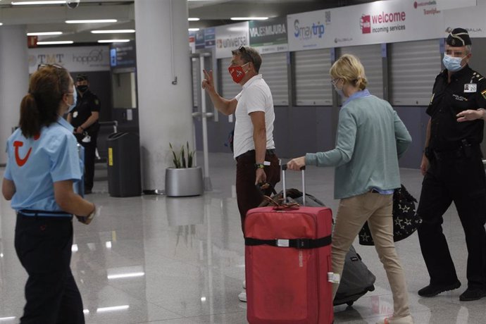 Dos viajeros procedentes de Alemania llegan al Aeropuerto de Palma de Mallorca el día en el que arranca en Baleares el plan piloto 