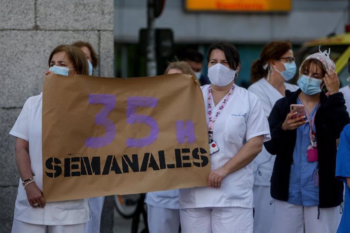 Personal sanitario del Hospital Clínico San Carlos de la Comunidad de Madrid sostienen carteles en los que se lee '35 horas semanales'.