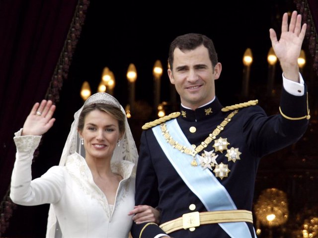 Spanish Crown Prince Felipe de Bourbon and his bride Letizia wave as the Royal couple appears on the balcony of Royal Palace May 22, 2004 in Madrid.