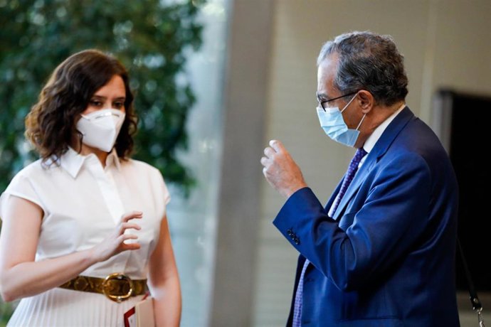 La presidenta de la Comunidad de Madrid, Isabel Díaz Ayuso (i) y el consejero de Educación, Enrique Ossorio (d) conversan antes de la sesión plenaria en la Asamblea.